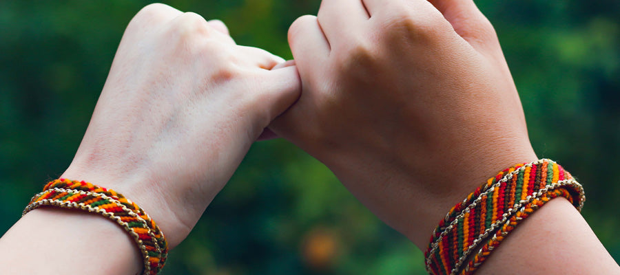 two friends showing friendship bracelets on wrists